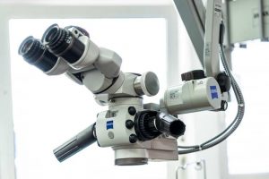 Mirkroskop mit großem Schwenkarm im Behandlungszimmer der Praxis ist zu sehen